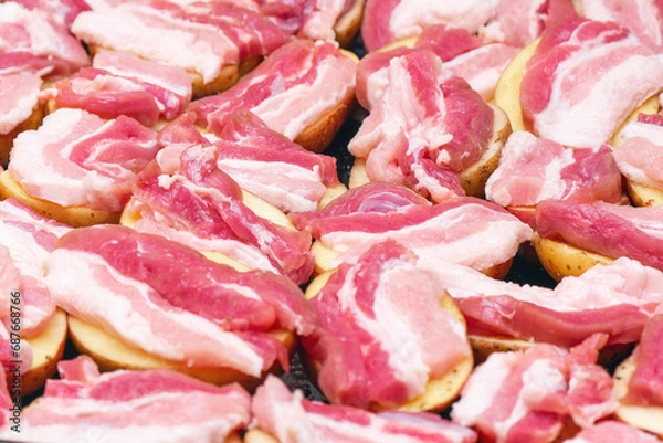 Fototapeta Raw potatoes with bacon, prepared for baking in the oven