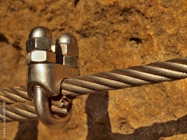 Fototapeta  Detail of iron twisted rope end anchored into sandstone rock.