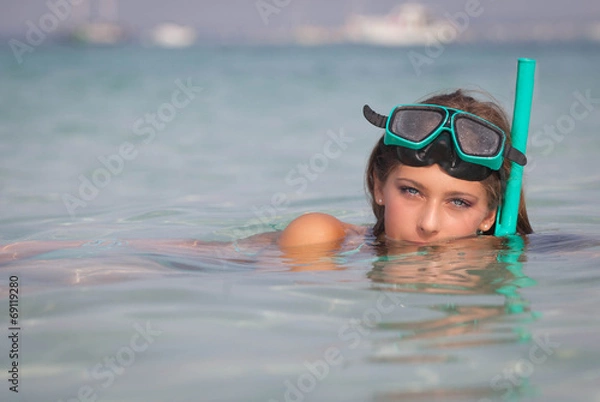 Fototapeta young woman relaxing in sea with snorkel and mask.