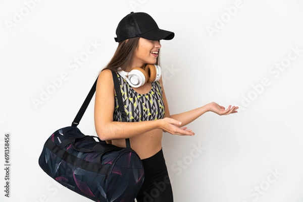 Fototapeta Young sport woman with sport bag isolated on white background with surprise expression while looking side