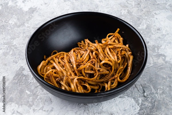 Fototapeta Noodles with onions, sesame seeds, spices and sauce.