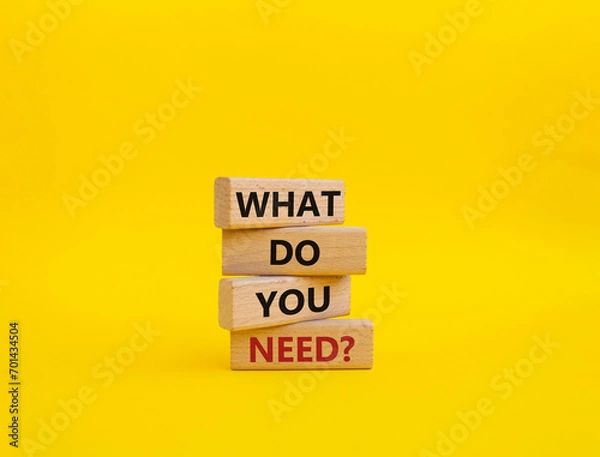 Fototapeta What do you need symbol. Wooden blocks with words What do you need. Beautiful yellow background. Business and What do you need concept. Copy space.