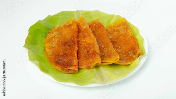 Fototapeta Sweet Boli, Stuffed with a delectable mixture of palm jaggery, coconut, and aromatic cardamom, each bite of Sweet Boli unfolds a symphony of flavors.