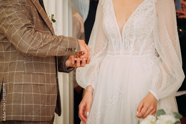 Fototapeta The image features a person wearing a white wedding dress, with embellishments and lace 5262.