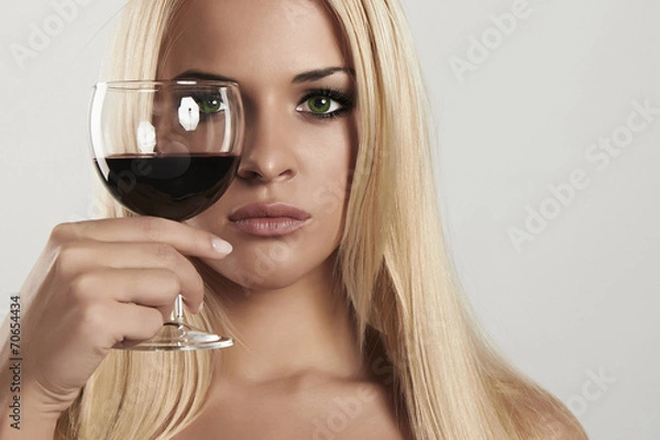 Fototapeta Beautiful blond woman with red wine.look in glass.drink