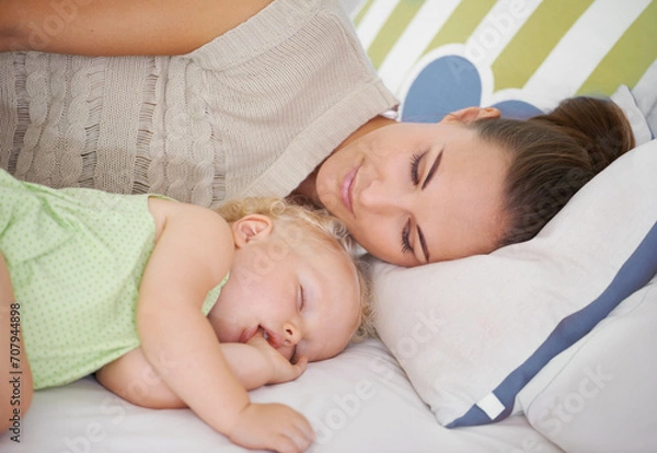 Fototapeta Love, sleeping and mom with baby on bed for bonding, relax and sweet cute relationship. Happy, smile and young mother watching girl child, kid or toddler taking a nap in bedroom or nursery at home.