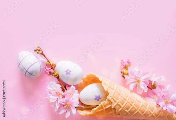 Fototapeta Creative Easter photo with copy space. Easter eggs, cherry blossom flowers, ice cream cone on pink background. Church Christian holidays, Christianity