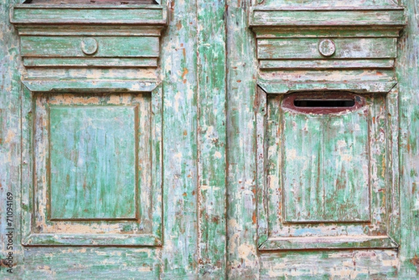 Fototapeta Old worn wooded door with green paint peeling off