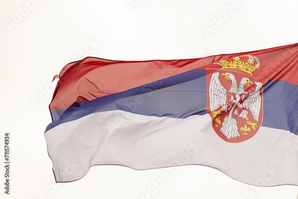 Fototapeta Flag of Serbia. A large Serbian flag flutters in the wind. Close-up. Great for news. National Flag of Serbia on a white background