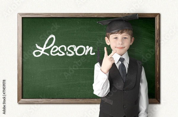 Fototapeta Cheerful little boy on blackboard. Looking at camera