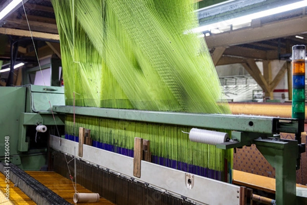 Fototapeta Modern Carpet weaving factory. Carpet making machine needle. Yarn bobbins attached to a carpet weaving machine. Inside Interior of a Fabric Weaving Factory.