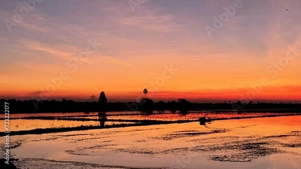 Fototapeta In the countryside, under a vanilla sky at sunset in the field.