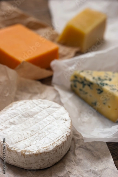 Fototapeta Assorted cheeses on the wooden table