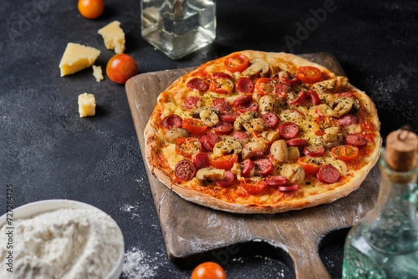 Fototapeta Homemade pizza with mushrooms, sausage, tomatoes and cheese. Simple country food.