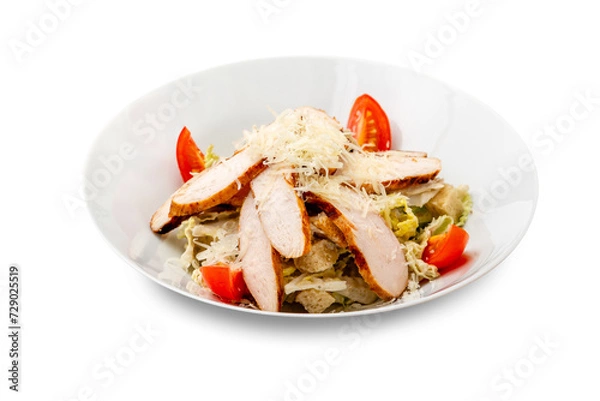 Fototapeta Caesar salad with chicken in a white plate. Isolated.