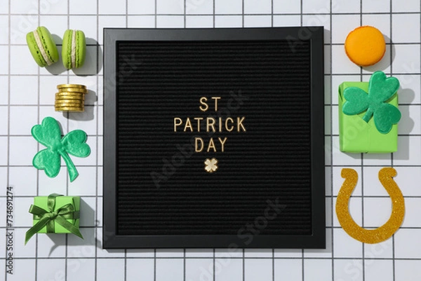 Fototapeta Black letter board with text, boxes, coins and clover leaves on light background, top view