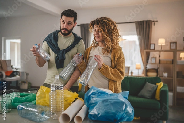 Fototapeta husband and wife recycle at home sorting waste plastic paper and glass