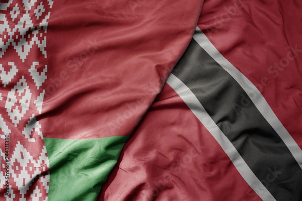 Fototapeta big waving national colorful flag of trinidad and tobago and national flag of belarus.