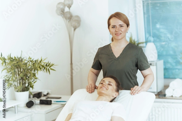 Fototapeta smiling female medical massage therapist in massage cabinet