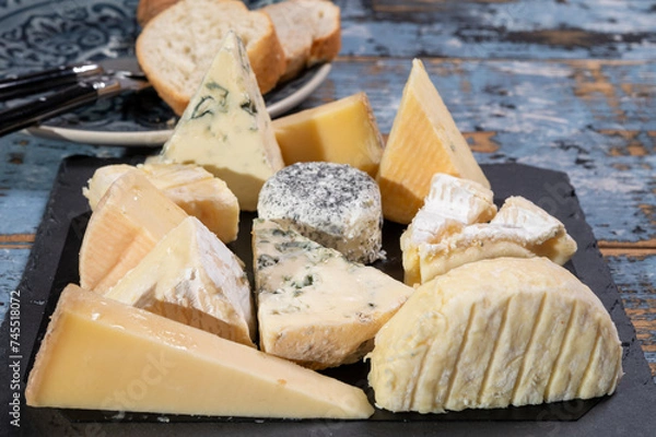 Fototapeta Tasting plate with small pieces of different French cheeses, variety of cheeses