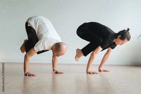 Fototapeta two young athletes practice yoga in the gym. Joint training, indoors, studio. The concept of a healthy lifestyle