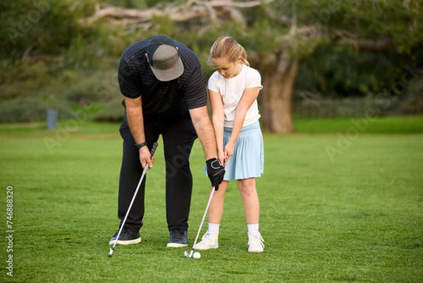 Fototapeta A father and Daughter play golf on a golf course