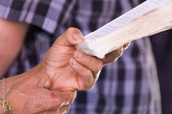 Fototapeta Hand holding book to read while sitting in a car, concept of eye