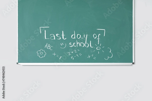 Fototapeta Blackboard with text LAST DAY OF SCHOOL and drawings on white wall