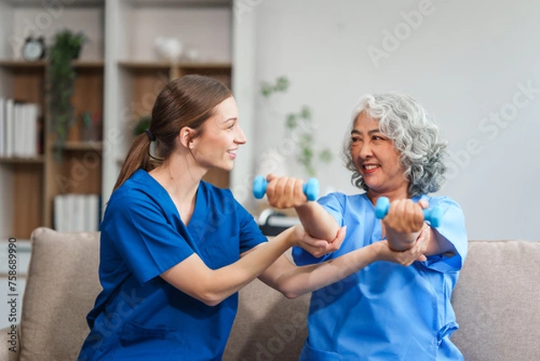 Fototapeta A young Caucasian physical therapist and an elderly Asian woman in her 60s attended a physical therapy course regarding muscle pain and muscle weakness. and heel pain with elastic bands