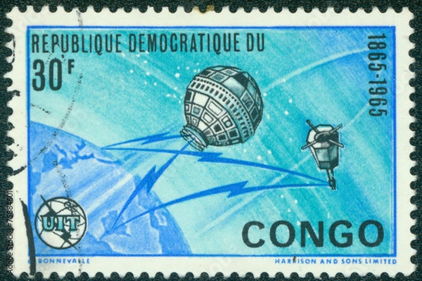 Fototapeta stamp  shows image of the Earth and satellites