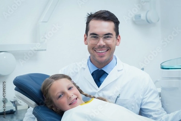 Fototapeta Male dentist examining girls teeth