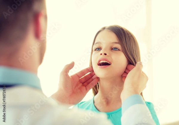 Fototapeta male doctor checks little girl lymph nodes