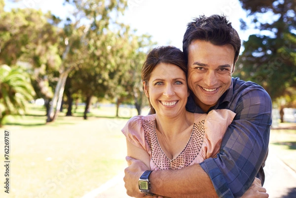 Fototapeta Couple, portrait and happiness at park with hug for bonding, relax and summer date outdoor in Amsterdam. Man, woman and face with smile in nature with healthy relationship, anniversary and embrace