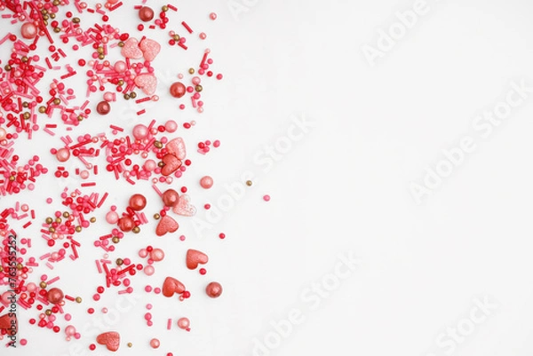 Fototapeta Sweet pink sprinkles scattered on white background