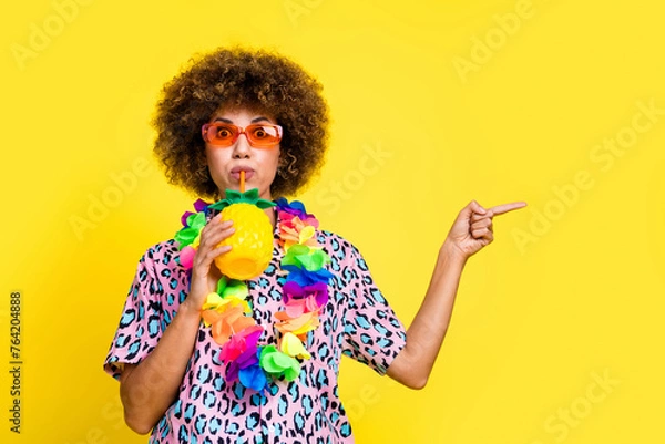 Fototapeta Photo of impressed funky woman wear print shirt dark glasses drinking cocktail showing empty space isolated yellow color background