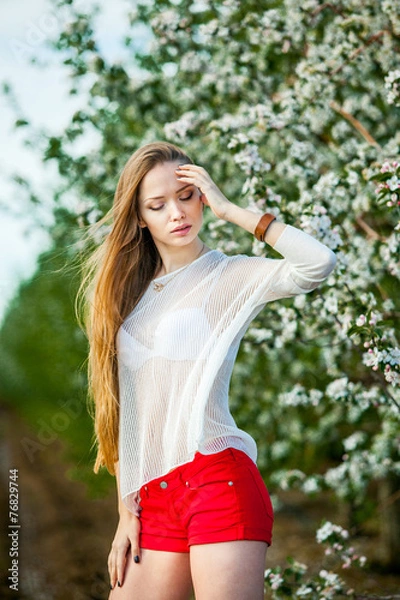 Fototapeta Spring portrait of a woman in a flowered garden