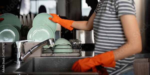 Fototapeta Woman washing up at home dishes in sink