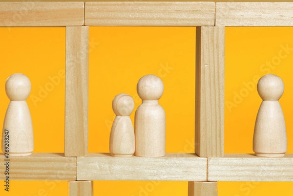 Obraz People staying in their flats in apartment house, hospital or prison. Wooden figurines on yellow background