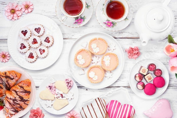 Fototapeta Mother's Day tea table scene over a white wood background. Selection of sweet desserts and pastries.