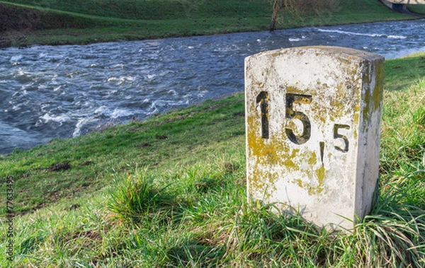 Fototapeta Old Milestone at the river