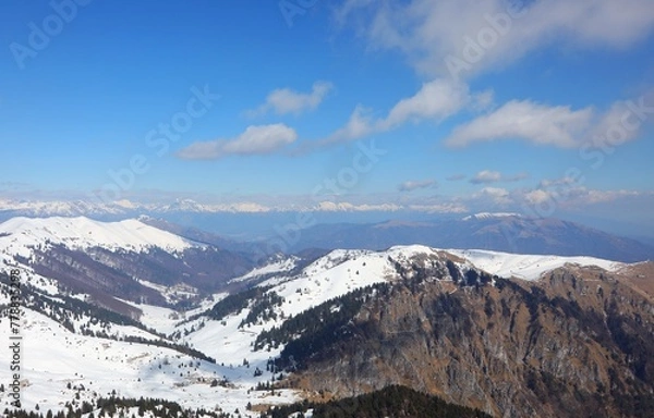 Fototapeta Breathtaking natural landscape of the European Alps in northern Italy with snow-capped mountain peaks  in winter