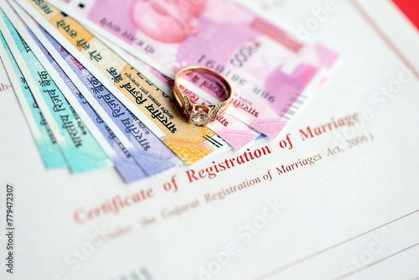 Fototapeta Indian Certificate of registration of marriage blank document and wedding ring with rupiah money on table close up