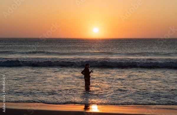 Fototapeta Niño practicando pesca en un atardecer