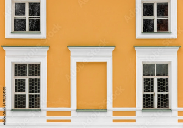 Fototapeta Decorated yellow wall with windows in white frames