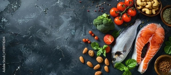 Fototapeta Food sources of omega 3 and healthy fats displayed on a dark background from a top-down perspective, with space for additional content. Included are vegetables, seafood, nuts, and seeds.