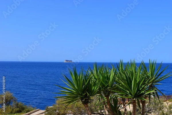 Obraz ZURRIEQ, MALTA - Augusts 06, 2021: The Blue Grotto - A famous sea cave surrounded by the deep blue sea at southern Malta. On a traditional boat surrounded by more brightly coloured boats. 