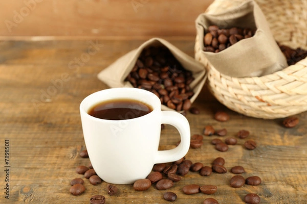 Fototapeta Cup of coffee with beans on rustic wooden background