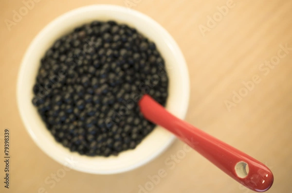 Fototapeta black lentils in a porcelain cup close up