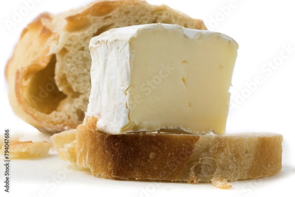 Fototapeta macro closeup of a wedge of brie cheese with a slice of French baguette isolated on white