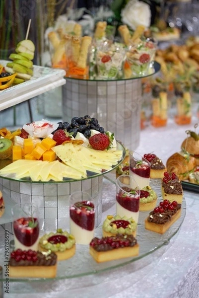 Fototapeta Catering Buffet with Pastries, Fruit, and Cheese on Platters and Trays